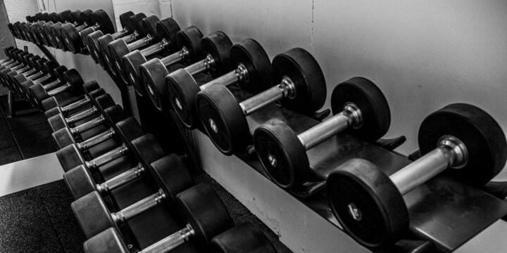 Black and silver dumbbells neatly stored on a black steel rack